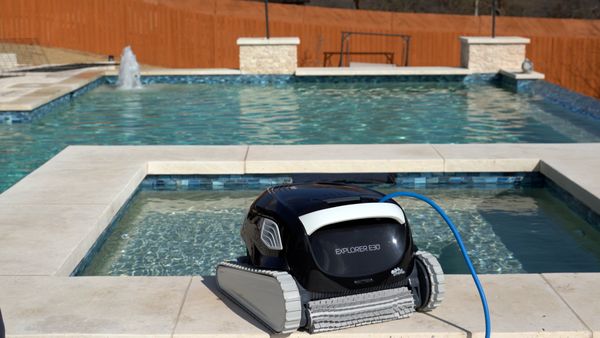 Dolphin Explorer E30 on a pool ledge mid-cycle