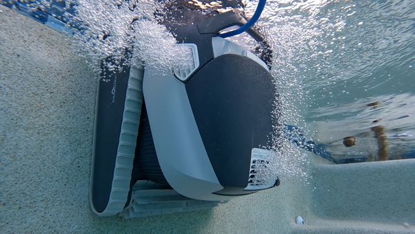 Dolphin Quantum driving across the pool floor with its dual brushes engaged