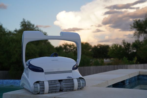 Dolphin Sigma sitting on the pool ledge against a blue sky